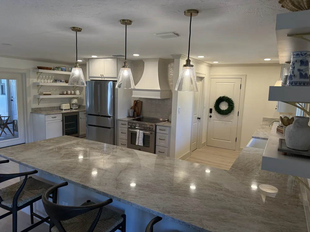 Remodeled kitchen with a stone island and pendant lights